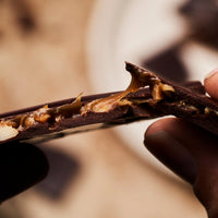 Cuvée Roasted Macadamia and Caramel dark chocolate bar showing salted caramel centre