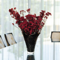 RUBY deep red preserved rice flower en masse in Lashay tall vessel amber by The Palmier, on a dining table